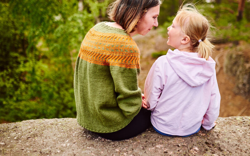 Aikuinen ja lapsi ulkona istumassa Coronaria sopeutumisvalmennus lapsille joilla diagnosoitu autismikirjon häiriö