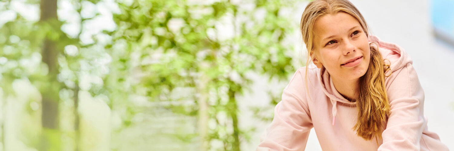 Tyttö hymyilee puistossa Coronarian LAKU-perhekuntoutus