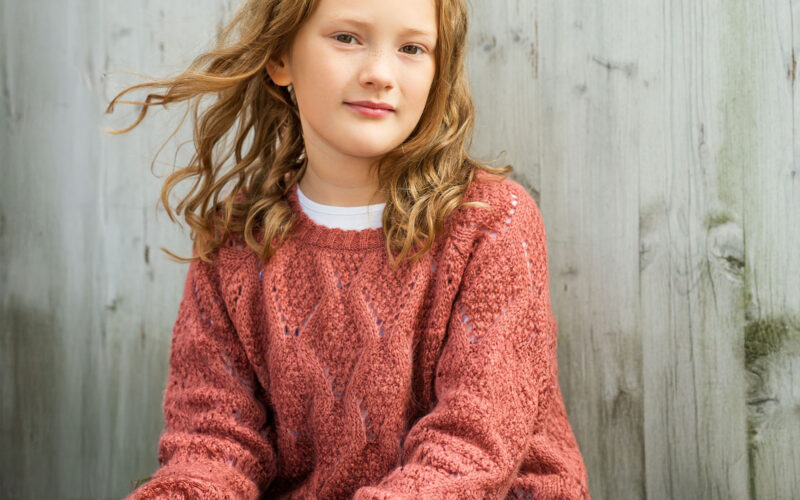 tyttö hymyilee lankkuseinän edessä Coronaria sopeutumisvalmennus ADHD ADD lapsille