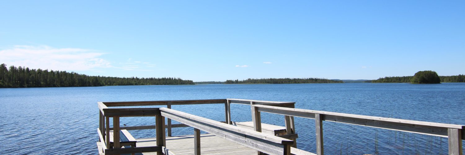 Kesäinen ja aurinkoinen vesistökuva, jonka etualalla on laituri.