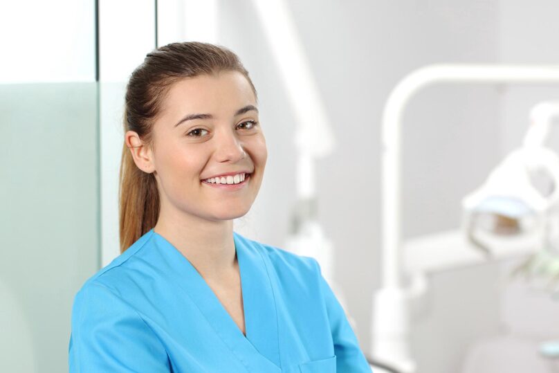 Hammashoitaja nainen hymyilee lähikuvassa.