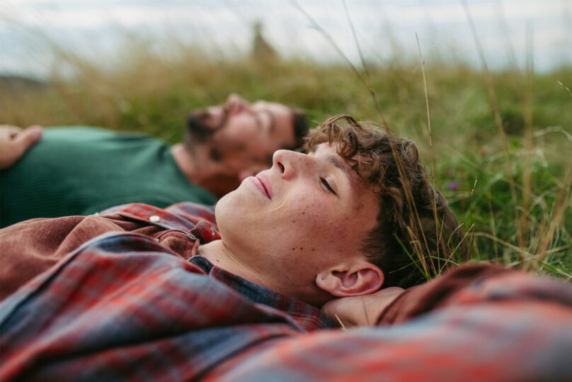 Isä ja poika makoilevat nurmikolla Coronaria psykiatrin vastaanotto