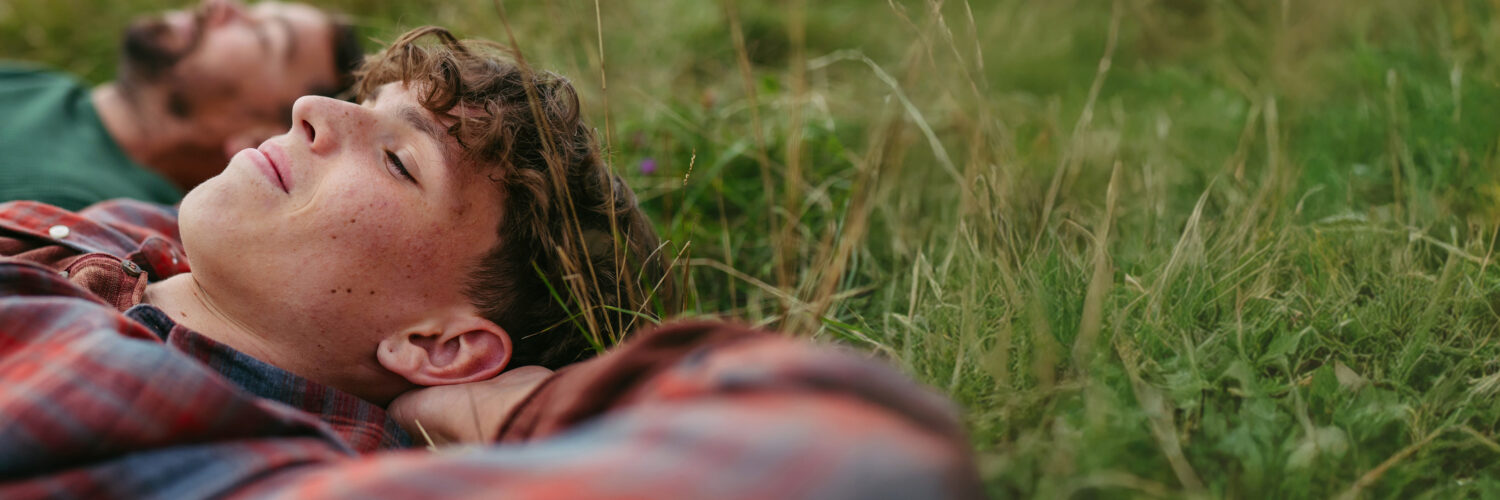 Isä ja poika makaavat nurmikolla Coronaria psykiatrin vastaanotto