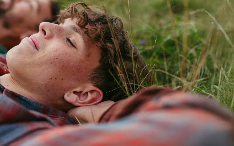 Isä ja poika makoilevat nurmikolla Coronaria psykiatrin vastaanotto