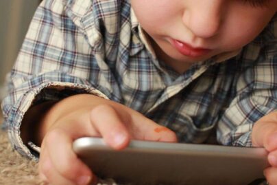 Lapsi tutustuu kännykkään lattialla