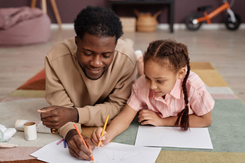 Isä ja tytär piirtävät yhdessä perheterapiassa