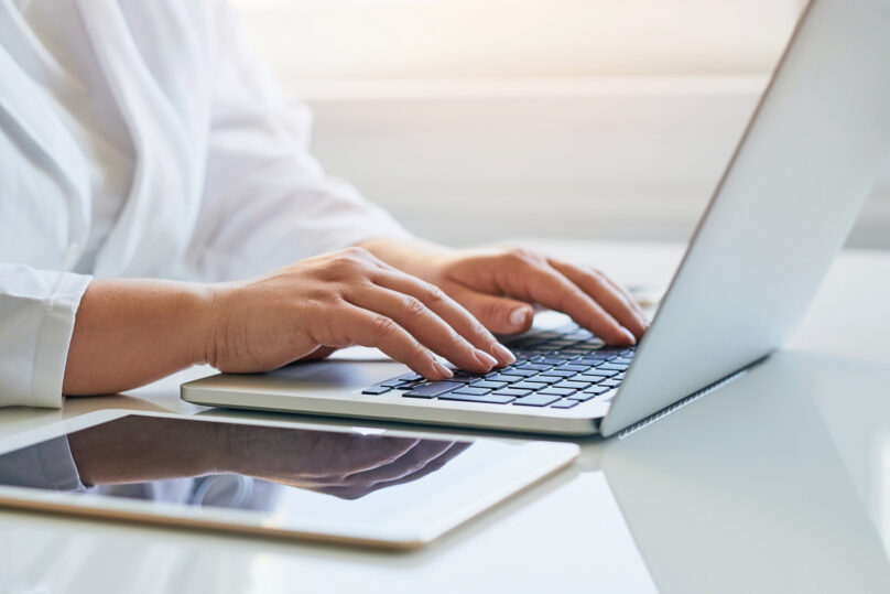 Lääkärin kädet kirjoittamassa kannettavalla tietokoneella.