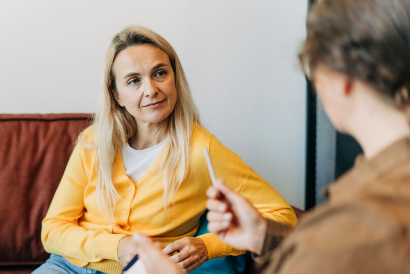 nainen ja asiantuntija keskustelevat coronaria psykoterapia