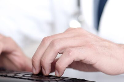 Mieslääkärin kädet näppäimistöllä
