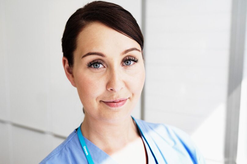 silmahoitaja katsoo kameraan ja hymyilee