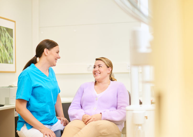 Hammaslääkäri ja potilas juttelevat hammaslääkärin huoneessa.