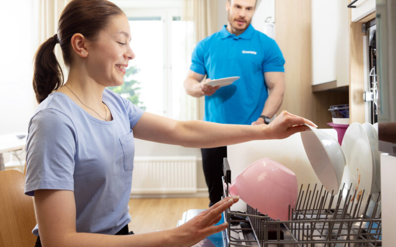 Coronaria kuntoutuspalvelut toimintaterapian asiakas täyttää tiskikonetta.