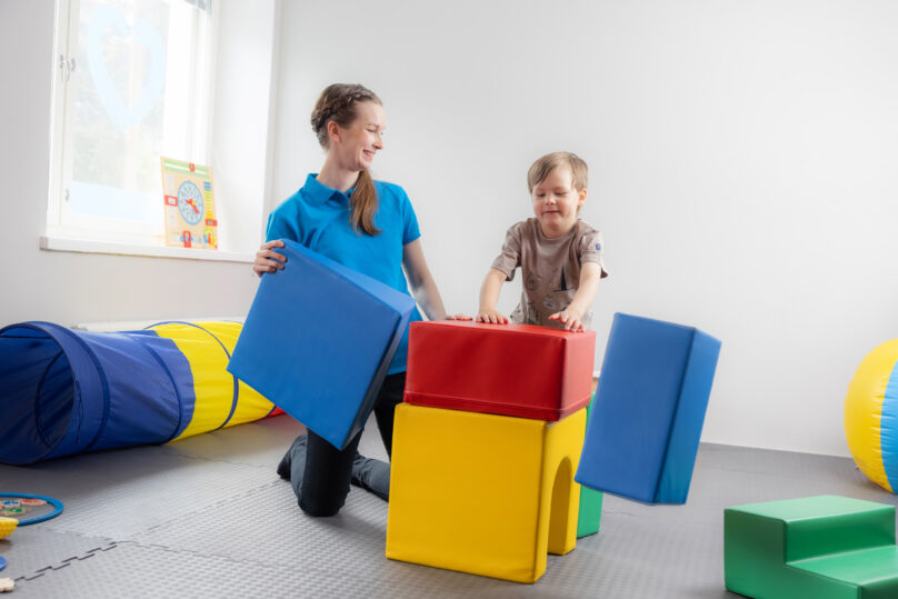 Coronaria kuntoutuspalvelut toimintaterapian lapsiasiakas rakentaa tornia terapeutin kanssa.