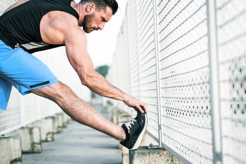 Mies lenkillä ja venyttää jalkaterää.