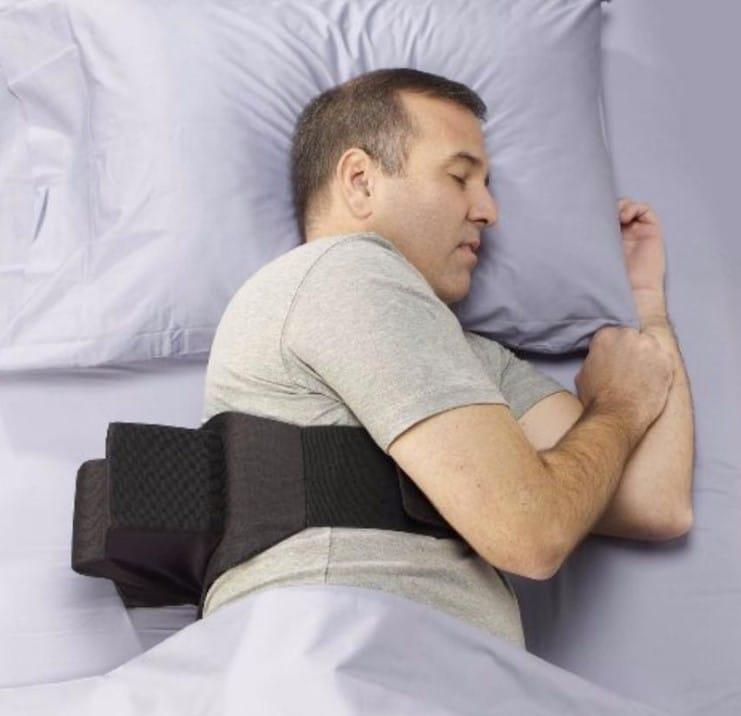 Mies nukkuu kyljellään asentovyö päällään.