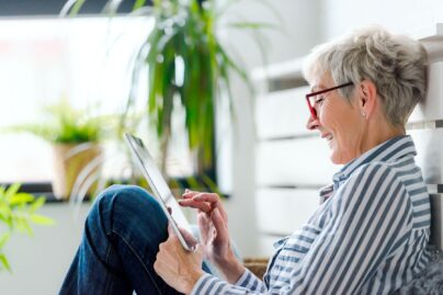 nainen tablettitietokoneen ääressä