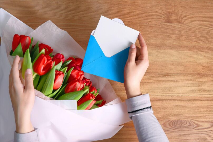 kukkakimppu ja avattu kirjekuori