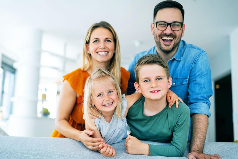 onnellinen perhe hymyilee kameralle