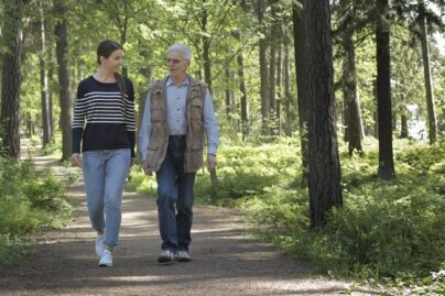 Nainen ja vanhempi mies kävelyllä puistossa.