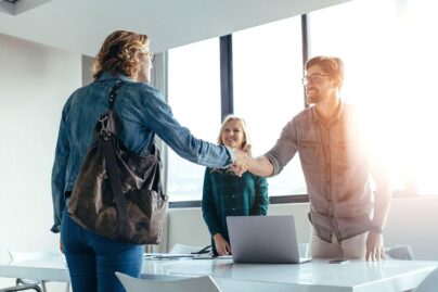 Toimistossa kolme henkilöä kättelevät