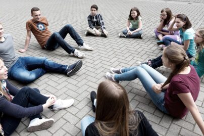 Nuorisoryhmä istuu ringissä pihalla