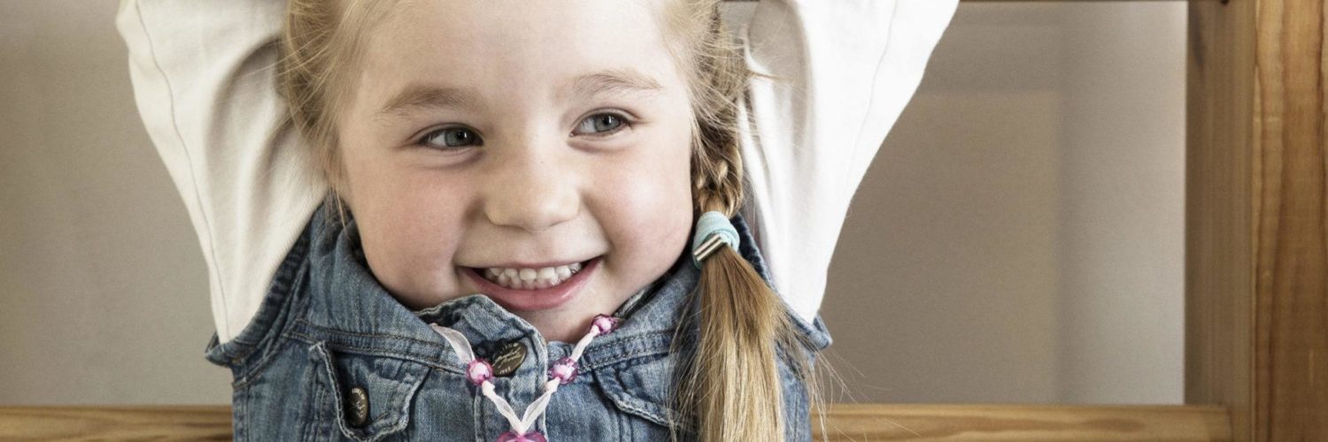 Tyttö roikkuu puolapuissa ja hymyilee