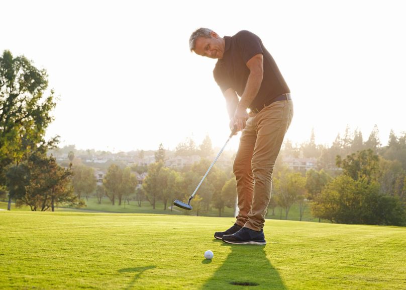 Vanhempi mies golfaamassa kesällä.