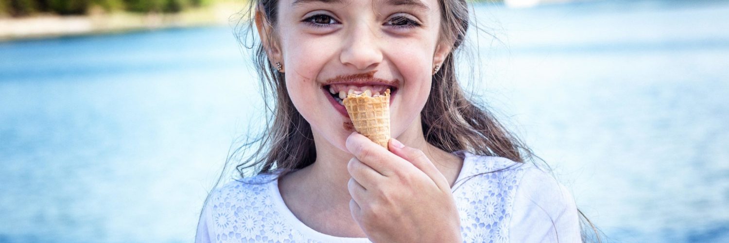 Nuori tyttö syö jäätelöä kesäpäivänä