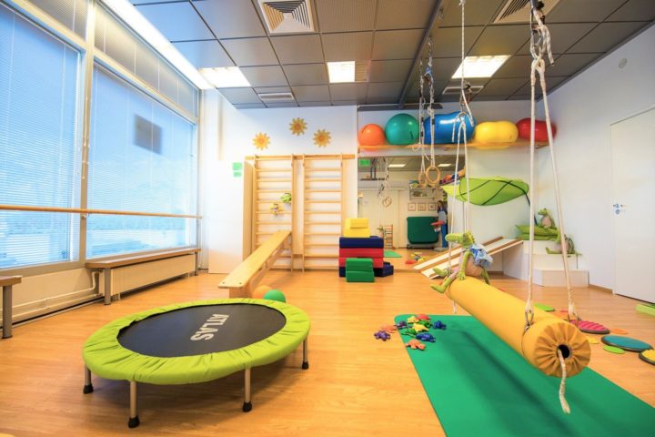 Coronaria lastenterapia Verson toimintasali, jossa paljon värikkäitä jumppavälineitä, kuten trampoliini ja keinu.