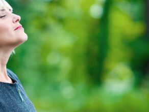 Vaalea nainen ulkona hengittää raikasta ilmaa.