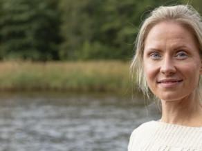 Nainen seisoo vesistön rannalla.