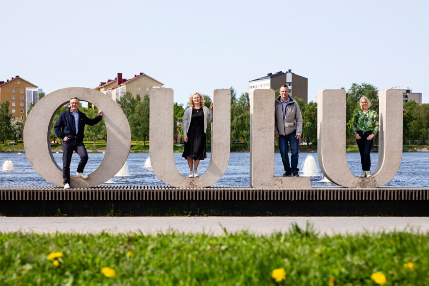Arto Lamberg, Piia Pesola, Anssi Åkman ja Jaana Isohätälä Oulu-kirjainten edessä Ainolan puistossa.