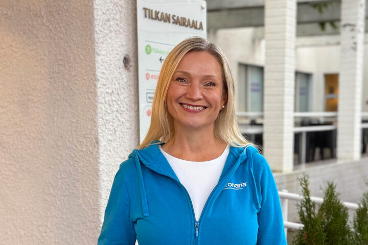 Puolikuvassa hymyilevä nainen.