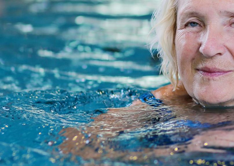 Seniorinainen uimassa uimahallissa
