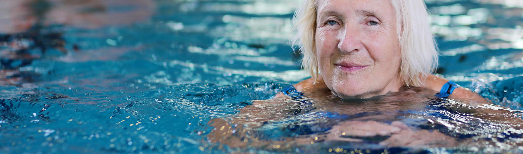 Seniorinainen uimassa uimahallissa