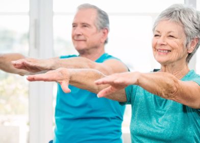seniorinainen ja seniorimies tekevat tasapainoharjoituksia kadet suoristettuna eteenpain