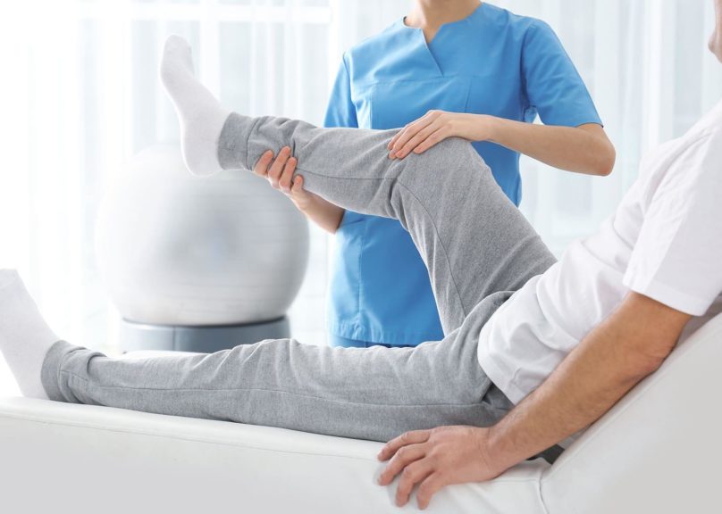 fysioterapeutti-tutkii-mies-asiakaan-jalkaa