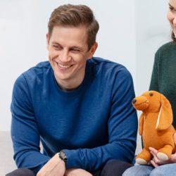 Tyttolapsi, isa ja aiti ovat perheterapiassa ja he hymyilevat toisilleen