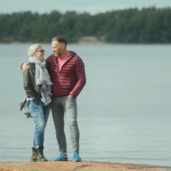mies ja nainen seisovat ulkona rantakalliolla