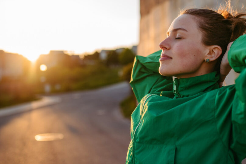 nuori nainen ulkoilemassa vihreässä takissa