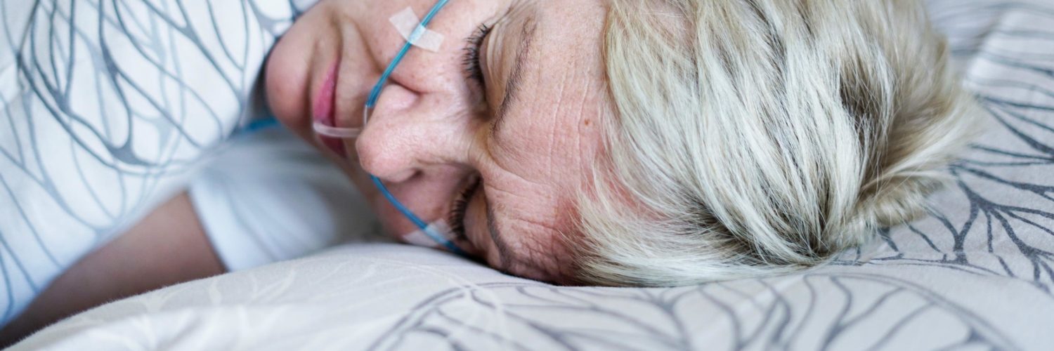 Vaaleahiuksinen nainen nukkuu uniapneatutkimuksen aikana.