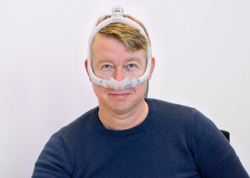 asiakas Mikko Heimo sovittaa CPAP-maskia