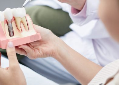 Naishammaslääkäri katselee hammasproteesin mallia