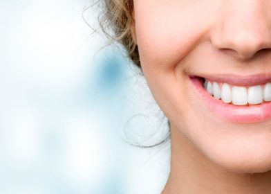 lahikuva hymyilevan naisen suusta valkoiset hampaat