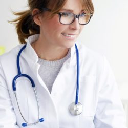 Naislääkäri ja naispotilas istuvat pöydän ääressä ja katsovat tietokonetta.