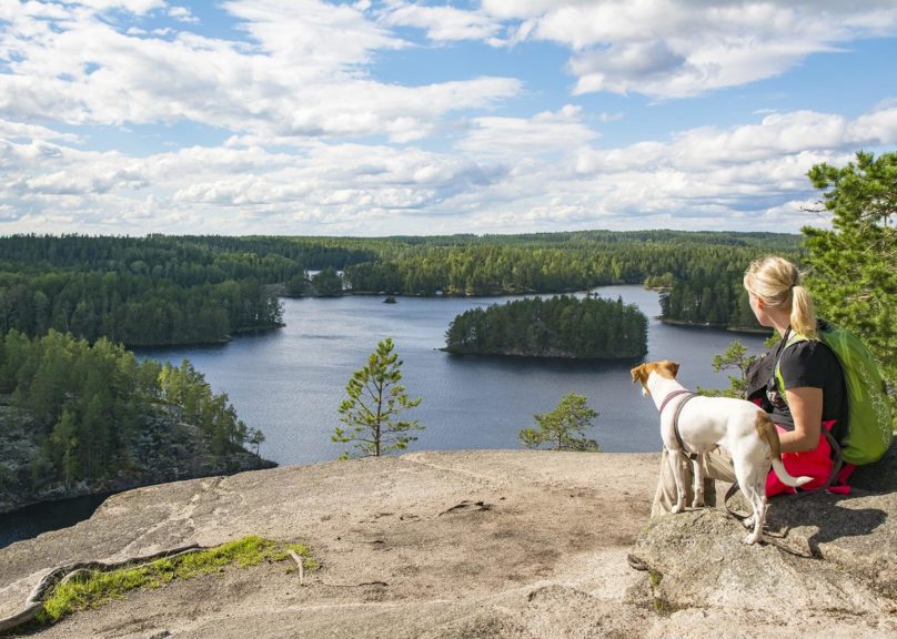 Nainen ja koira Lapissa kalliolla