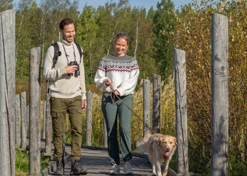 mies ja nainen ja koira kävelevat ulkona coronaria kuntoutuksessa